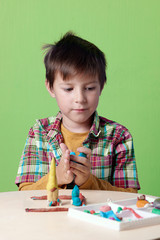 Caucasian boy is crafting with colorful modelling clay.