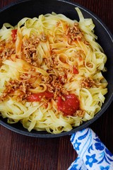 Delicious tagliatelle pasta with mince and tomatoes in a frying pan 