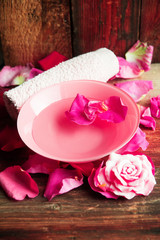 Spa setting with rose pink flowers and petals,bath salt and body-oil