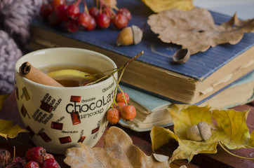 Cup of tea and autumn leaves, nuts, and berries 