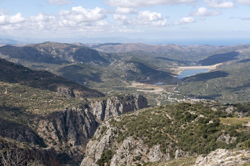 Fototapeta na wymiar View across mountains of a water reservoir from the mountain road at Ano Kera, Lasithi, Crete, Greece. October 2017