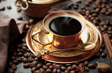 Black coffee in a cup on the table in a composition with coffee accessories on an old background
