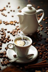 Black coffee in a cup on the background of coffee beans in a composition with accessories