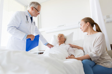 senior woman and doctor with clipboard at hospital