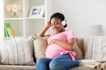 pregnant woman in headphones at home