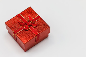 Single red gift box with silver ribbon on white background. Merry christmas, happy new year,valentine day concept.