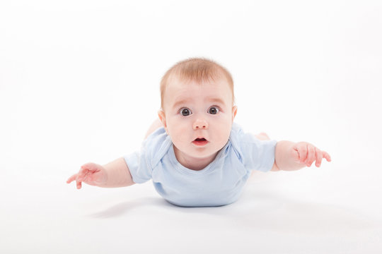 baby in the body lying on his stomach on a white background and looking at the camera