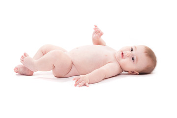 naked baby lies on his back and looks at the camera
