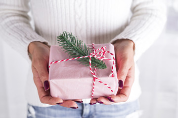 Woman's hands hold christmas gift box.