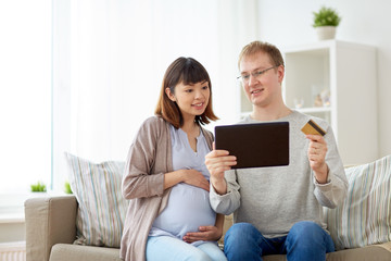 husband and pregnant wife shopping online at home