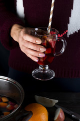 Hands holding glass of mulled wine