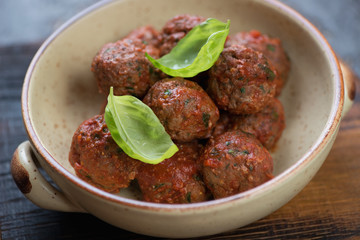 Close-up of a bowl with beef meatballs in tomato sauce, selective focus, shallow depth of field