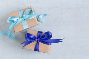 Christmas gift with blue ribbon on blue wooden table. Handmade gift concept with copy space.