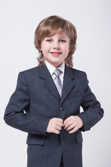 child in a classic suit straightens his jacket