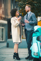 Two mixed race business people talking outside company with holding coffee break relaxing time concept.