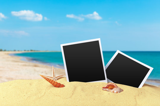 Pictue frame on shells and sand background. Copy space.