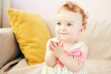 Fototapeta premium little girl claps her hands smiling