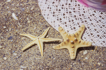 Beach Summer Vacation travel accessories on Sand background.