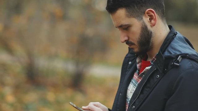 serious calm handsome man using smart phone mobile closeup side view tapping screen touch display gadget social networking media business finance appstore checking news email website organizer app pda