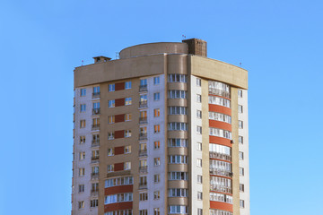 High multi-storey house in the city against the blue sky.