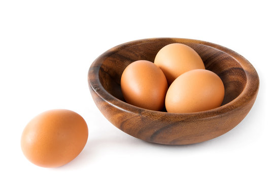 Chicken eggs brown in a wooden bowl close-up on a white background isolate
