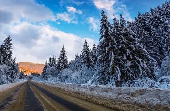 snowy road through mountains in evening. wonderful nature scenery in winter