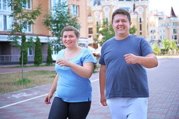 Overweight couple running, outdoors