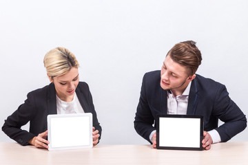 Picture of couple of office workers both holding tablet
