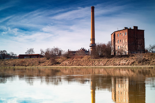 Poznan Garbary - a view above the river Warta to an old industrial city district, blue sky above buildings from XIX th century. Spring in Greater Poland.