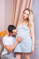 Pretty pregnant woman and her husband in studio