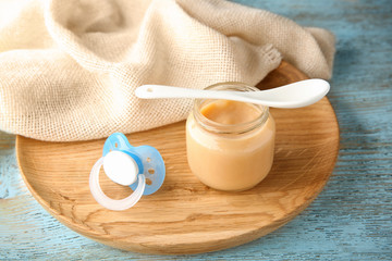 Jar of tasty baby food on table