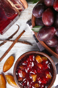 Bowl with delicious plum jam on table
