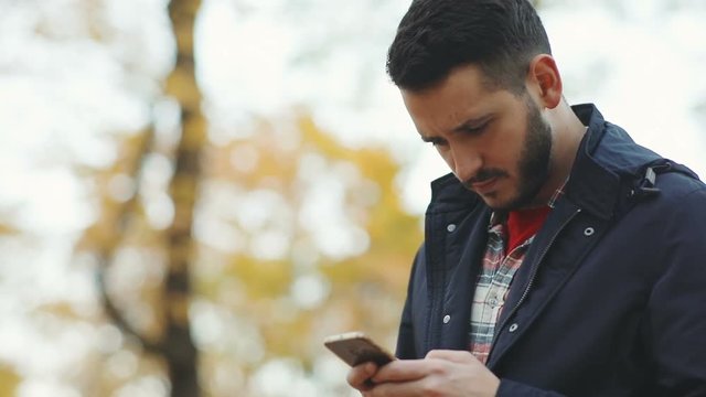 happy satisfied businessman man using smartphone outside blurred background trees autumn surprised emotional face bearded caucasian chat tapping message digital gadget tech development app store login