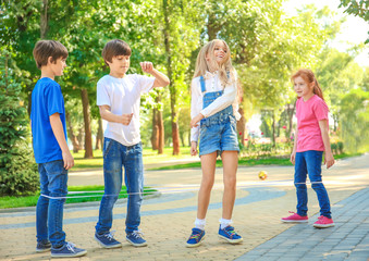 Cute little children jumping rope in park