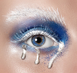 Beautiful female eye close-up. Blue eyes. Creative makeup