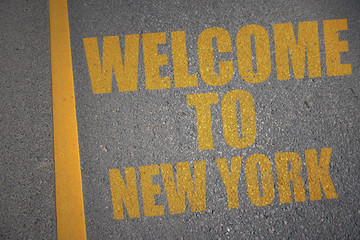 asphalt road with text welcome to new york near yellow line.