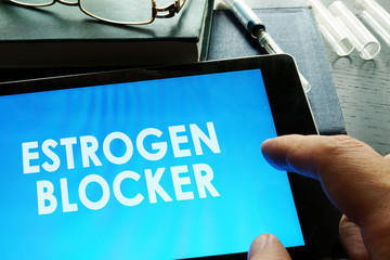Estrogen blocker. Doctor holding tablet with sign.