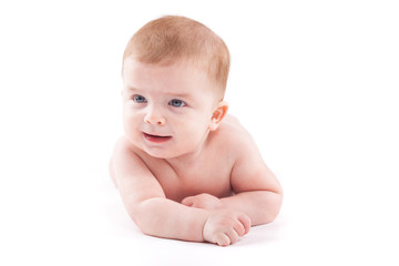 cute pretty little boy in white diaper lies on belly