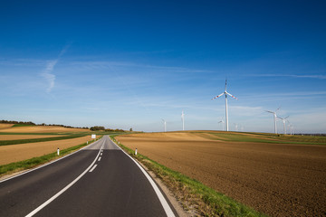 white wind power plants in a field