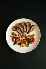 Racks of lamb on plate, isolated over black background