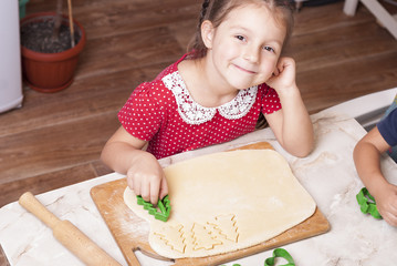 little girl is cooking gingerbread