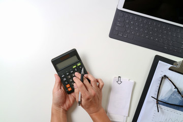 Fototapeta premium top view of businessman hand working with finances about cost and calculator and latop with mobile phone on withe desk in modern office