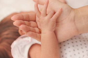 Obraz na płótnie Canvas mother holds little hand of newborn baby