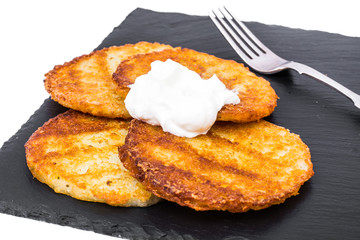 Potato pancakes with white sauce.