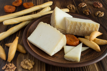 Pieces of cheese and bread sticks on the brown plate