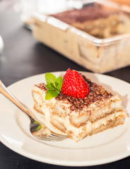 Homemade tiramisu cake decorated with strawberries Italian cuisine, Selective focus