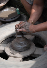 Potters hands on homemade potters wheel crafting a clay ceramic pot