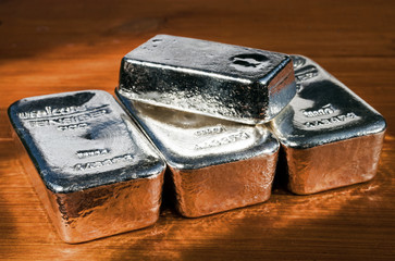 Silver bullion on red wood. Selective focus. .(feinsilber = fine silver)