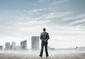 Motivation and inspiration concept with modern cityscape and businessman observing it