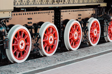 Wheels of an old steam locomotive close up.